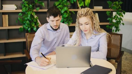 Deux professionnels qualifiés participent de manière productive à un projet collaboratif tout en travaillant ensemble