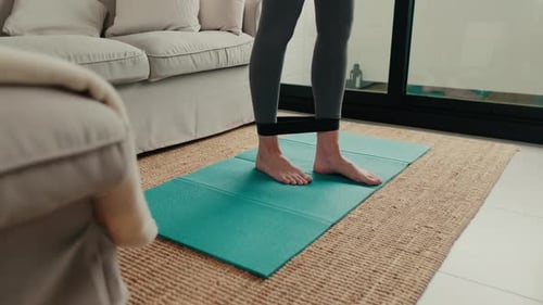 Woman Exercising with Resistance Band at Home