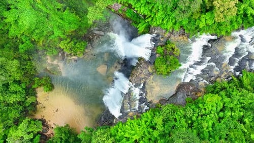 A waterfall in a beautiful tropical forest. Drone view.