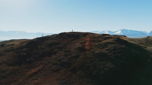 A Solo Hiker Explores a Scenic Mountain Landscape During a Clear Day