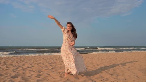 Elegant Woman Dancing Freely on Sandy Ocean Beach