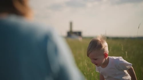 Kid Joyfully Jumping in a Sunny Grass Field with Blurred Background