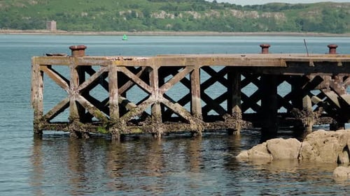Der Portencross Pier steht in der Nähe von verwittertem Wald und klarem schottischem Wasser