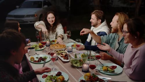 Friends Sharing Meal and Conversation at Outdoor Dinner