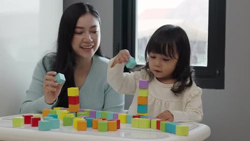 Woman and Girl Playing with Colorful Building Blocks