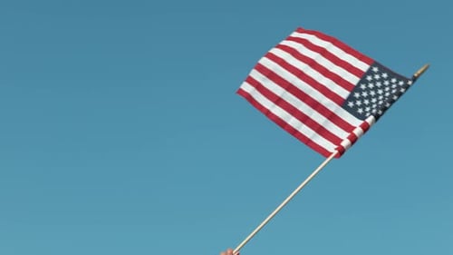 American flag waves against a blue sky
