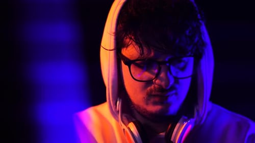 Young Adult in Hoodie with Headphones at Night