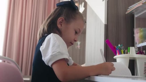 Girl Writing in Notebook at Her Desk