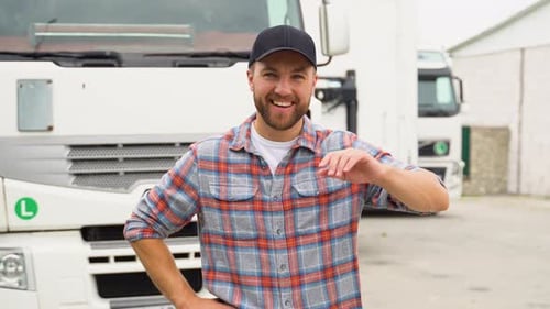 Retrato de motorista de caminhão barbudo profissional em roupas casuais ao lado de seu transporte de caminhão