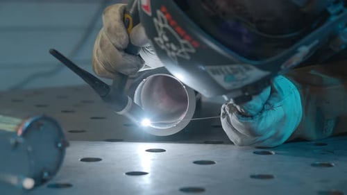 Skilled Welder Working on Metal Tubes