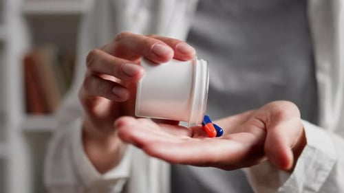 Pills Poured Into Hand from Container Close Up