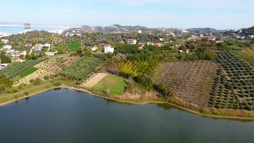 Aerial above agricultural fields and houses in Golem, Albania,