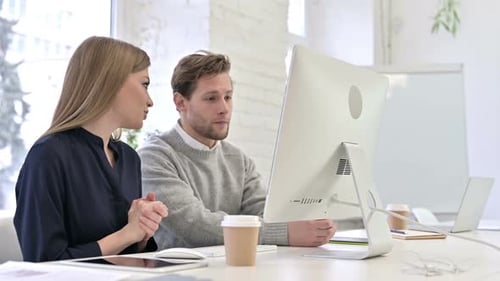 Young Adults Work Together on Computer in Office