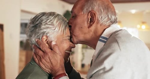Loving Senior Couple Kissing Indoors