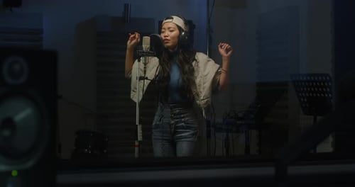 Portrait of a Professional Female Asian Singer Recording a Song in a Studio. Beautiful Y