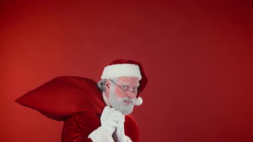 Papá Noel con un saco sale a escondidas para repartir regalos a los niños