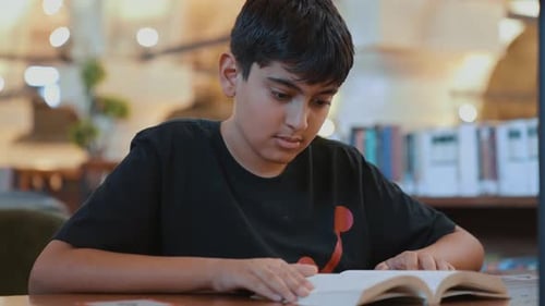 Junge liest ein Buch in der Bibliothek