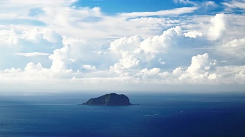 The blue sea, the blue sky, and the dynamic white clouds.