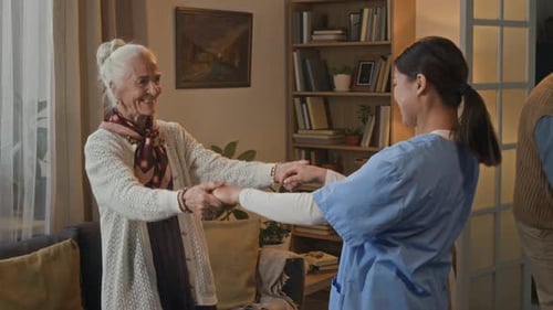 Senior Woman and Young Adult Dancing at Home