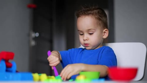Boy Playing with Colorful Clay at Indoor Table