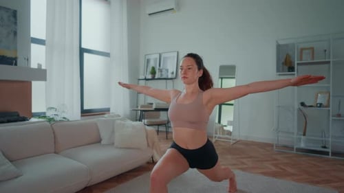 Woman Does Yoga Lunges in Modern Apartment