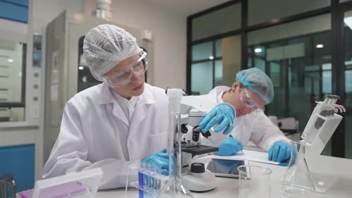 Scientists working in laboratory with microscope and equipment