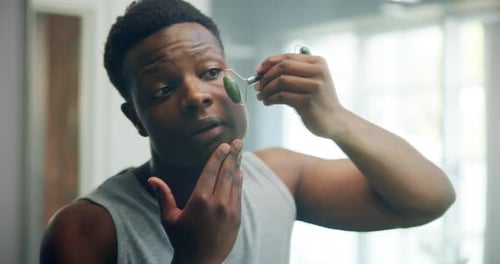 Man Using Jade Roller for Facial Massage
