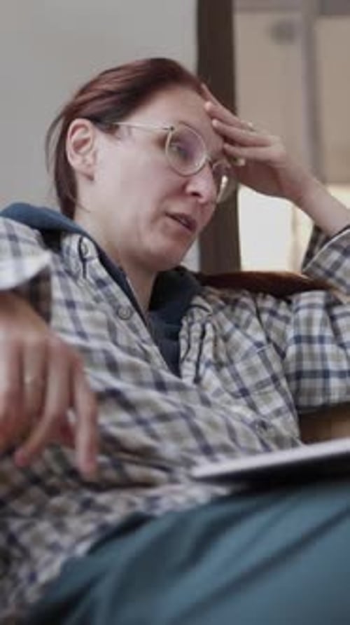 Woman Sitting on Sofa with Laptop Feeling Bored and Unmotivated