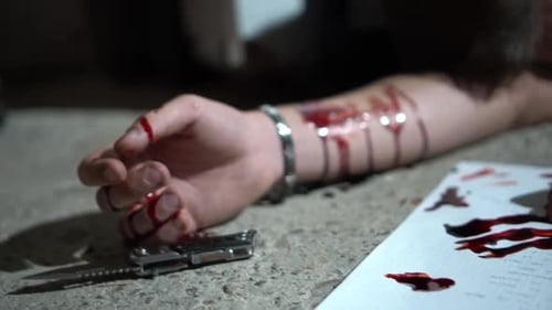 Leiche auf dem Boden mit durchgeschnittenen Adern, Messer und blutiger Hand