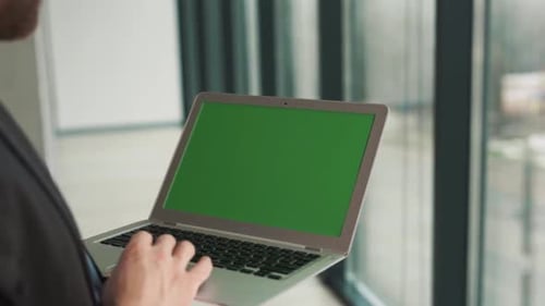 Close-up of a laptop screen with a chromakey in the hands of a man on the background of a panoramic