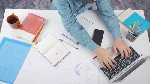 Person Typing on Laptop at White Office Desk