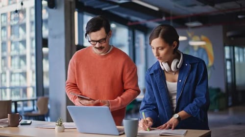 Young Adults Collaborating on Tech at Modern Workplace