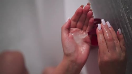 Woman Pumping Liquid from Bottle in Shower
