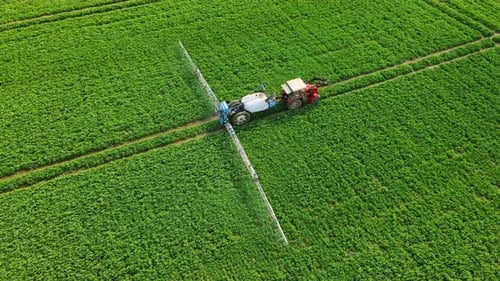 Farm Machinery Spraying Insecticide to Green Field