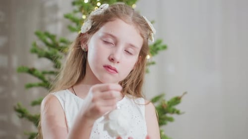 Child Holding a Christmas Ornament in Close Up