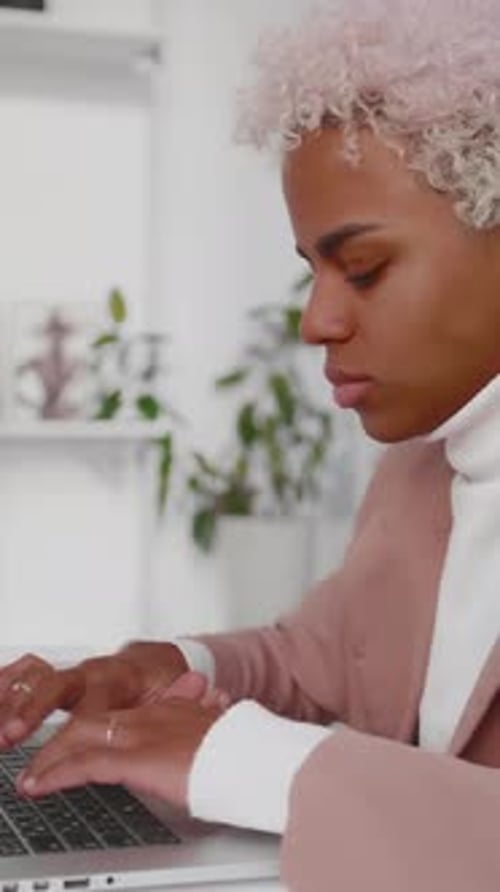 Un travailleur se concentre sur un ordinateur portable avec des plantes dans un espace intérieur lumineux
