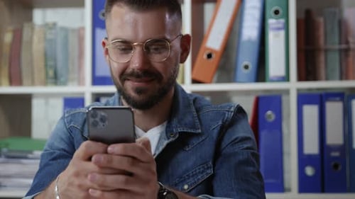 Man Using Mobile Phone at His Desk
