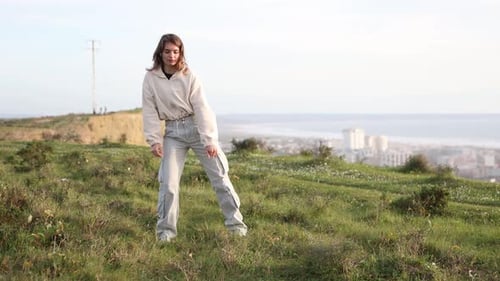 Young Woman Dancing Freestyle on a Hilltop Meadow