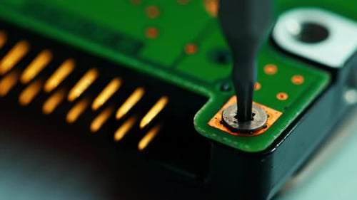 Screw Being Unscrewed from Green Circuit Board