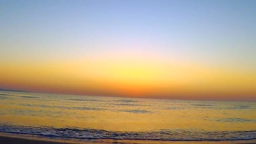 Golden Sunrise Over a Peaceful Beach and Ocean