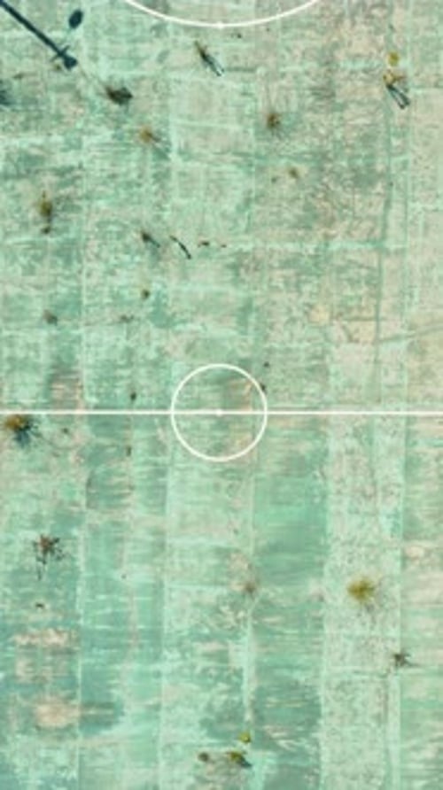 Aerial View of Abandoned Sports Court and Neglected Field Overrun By Nature Showing Signs of Decay