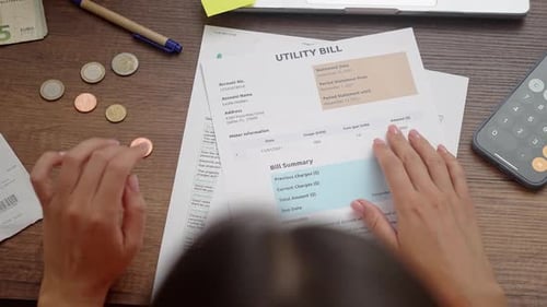 Calculating Expenses on Desk with Bills and Receipts