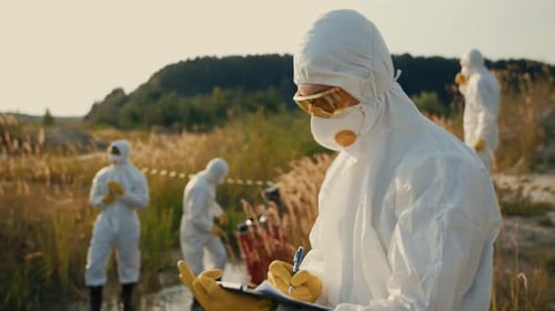 Scientists in Hazmat Suits Work in a Field