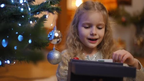 Little Girl Opening Gift on Christmas Day