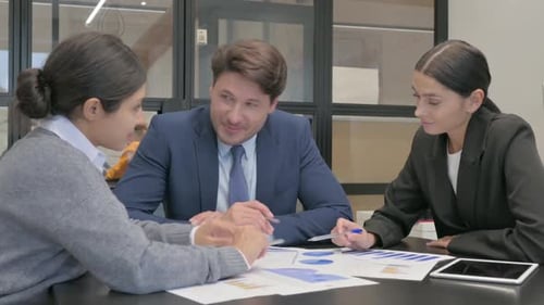 Team Discussing Charts in an Office Environment