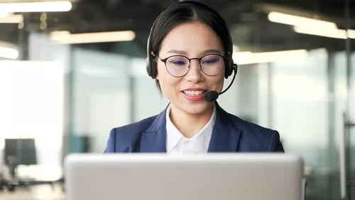 Smiling Woman Working on Laptop in Modern Office