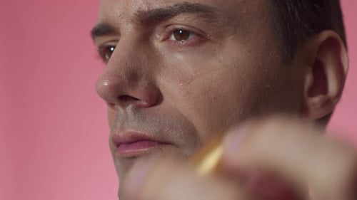 Caucasian Man Using Nourishing Serum on under Eyes Area