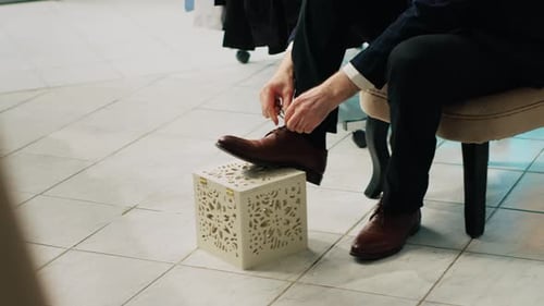 Man Tying Shoes Inside Retail Store