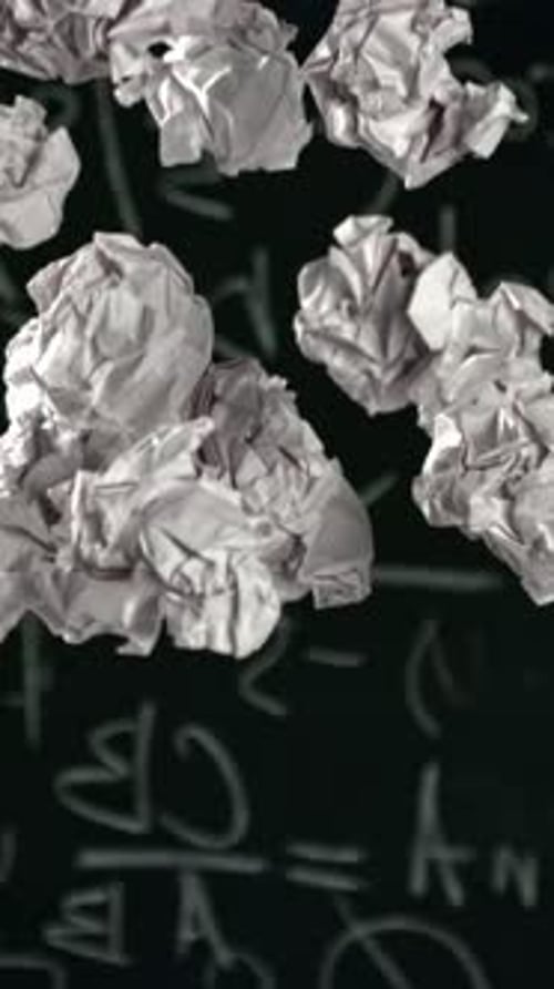 Crumpled Paper Rises and Falls Against the Background of the Blackboard Filmed on a Highspeed Camera
