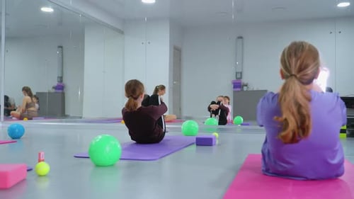 Group Workout with Instructor Oversight in Reflective Gym Setting